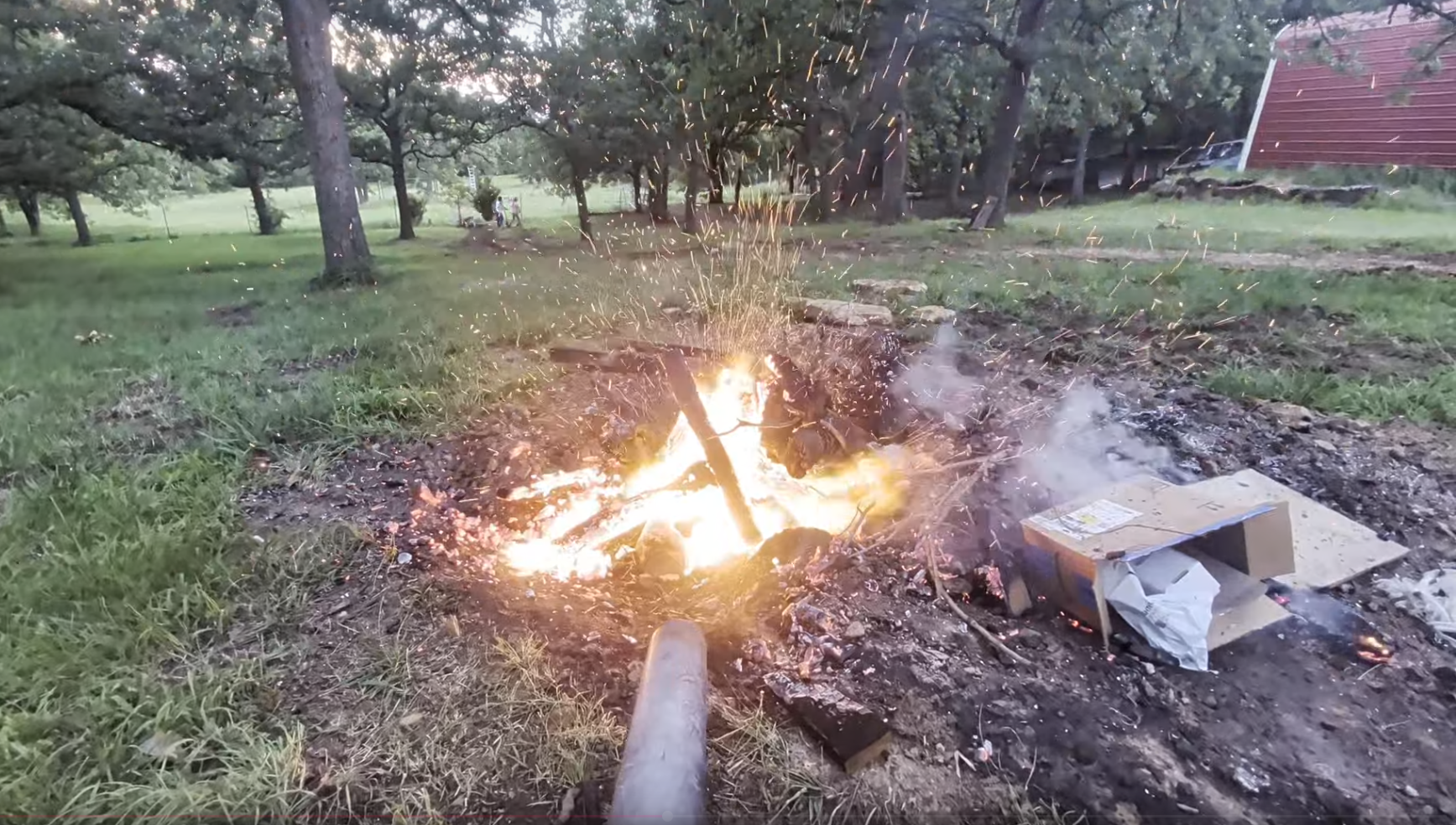 Leaf blower stoking the stump fire up to a bright burn