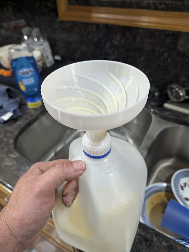 3D printed funnel sitting on top of a gallon jug