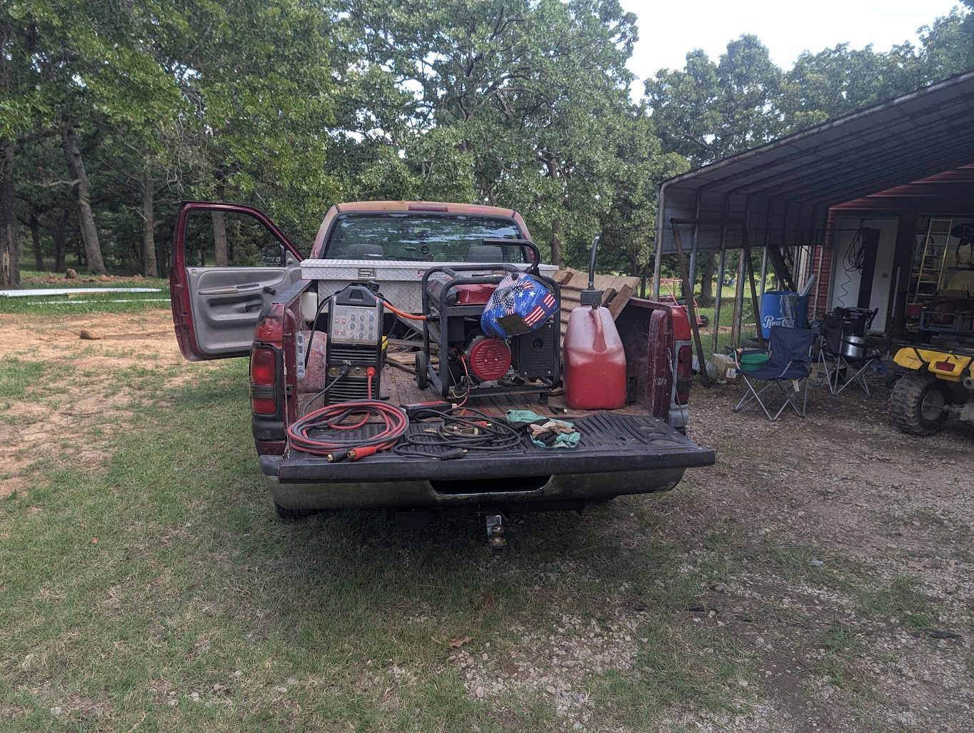 Truck bed loaded with generator, welder, fuel, and leads