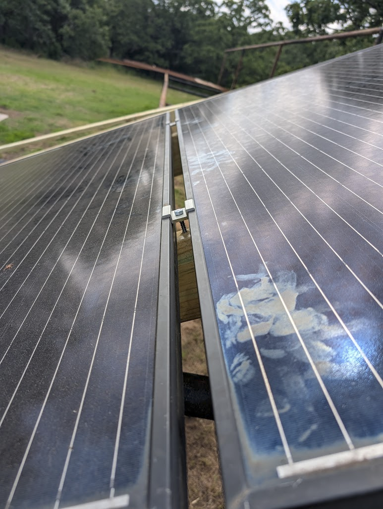 Mid-clamp installed between two panels, bolted down through the 2x6